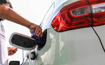 person puts fuel additive in car