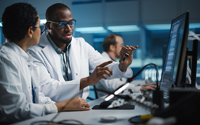 two individual in a lab look at semiconductor and talk