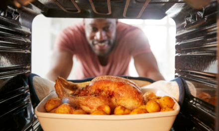 man takes chicken out of oven