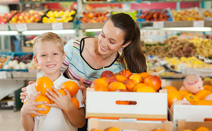 mother and son shop for oranges