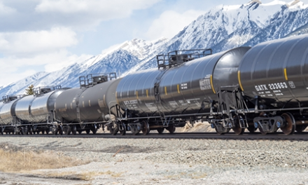crude oil cars on tracks with mountains in background
